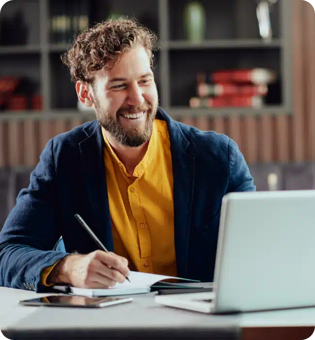 man smiling at his laptop