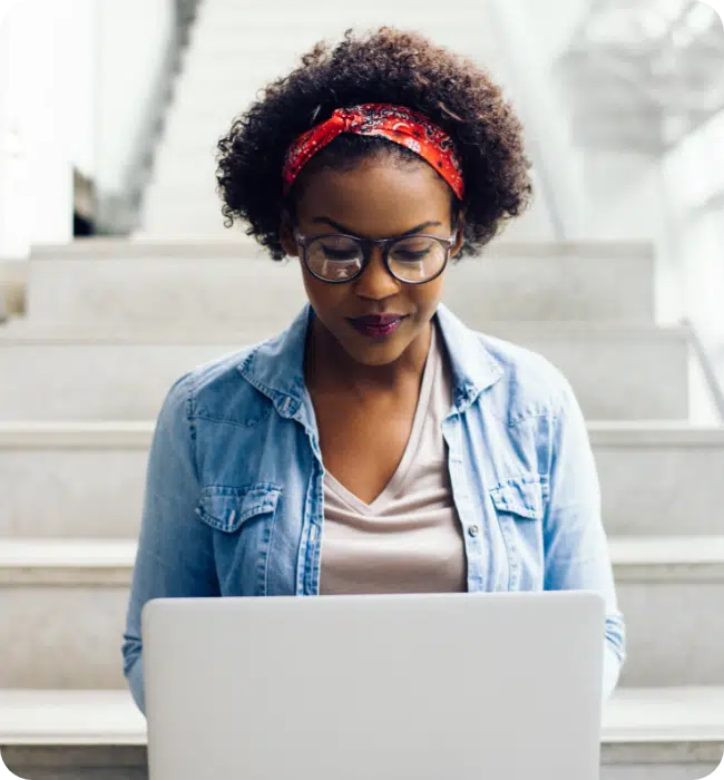 Apply your business rules, woman on a laptop on stairs.